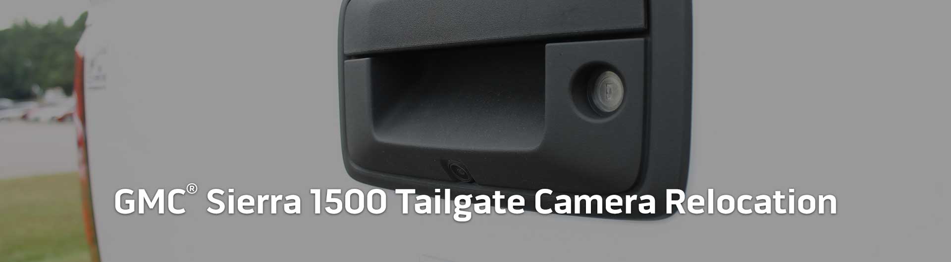 An image showing the tailgate of a GMC Sierra HD with a backup camera built into the tailgate handle.