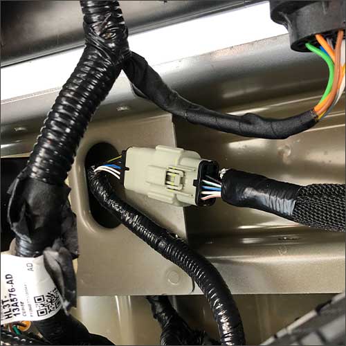 An image of the gray factory camera interface harness for a Ford F-150 with a manually-lowering tailgate