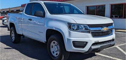 An image showing a white Chevrolet Colorado in a parking lot.