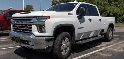 An image showing a white Chevrolet Silverado 2500 in a parking lot.