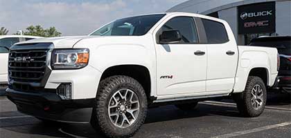 An image showing a white GMC Sierra 1500 truck in a parking lot.