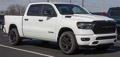 An image showing a white RAM 1500 truck in a parking lot.