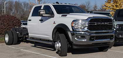 An image showing a white RAM truck with Cab and Chassis setup in a parking lot.